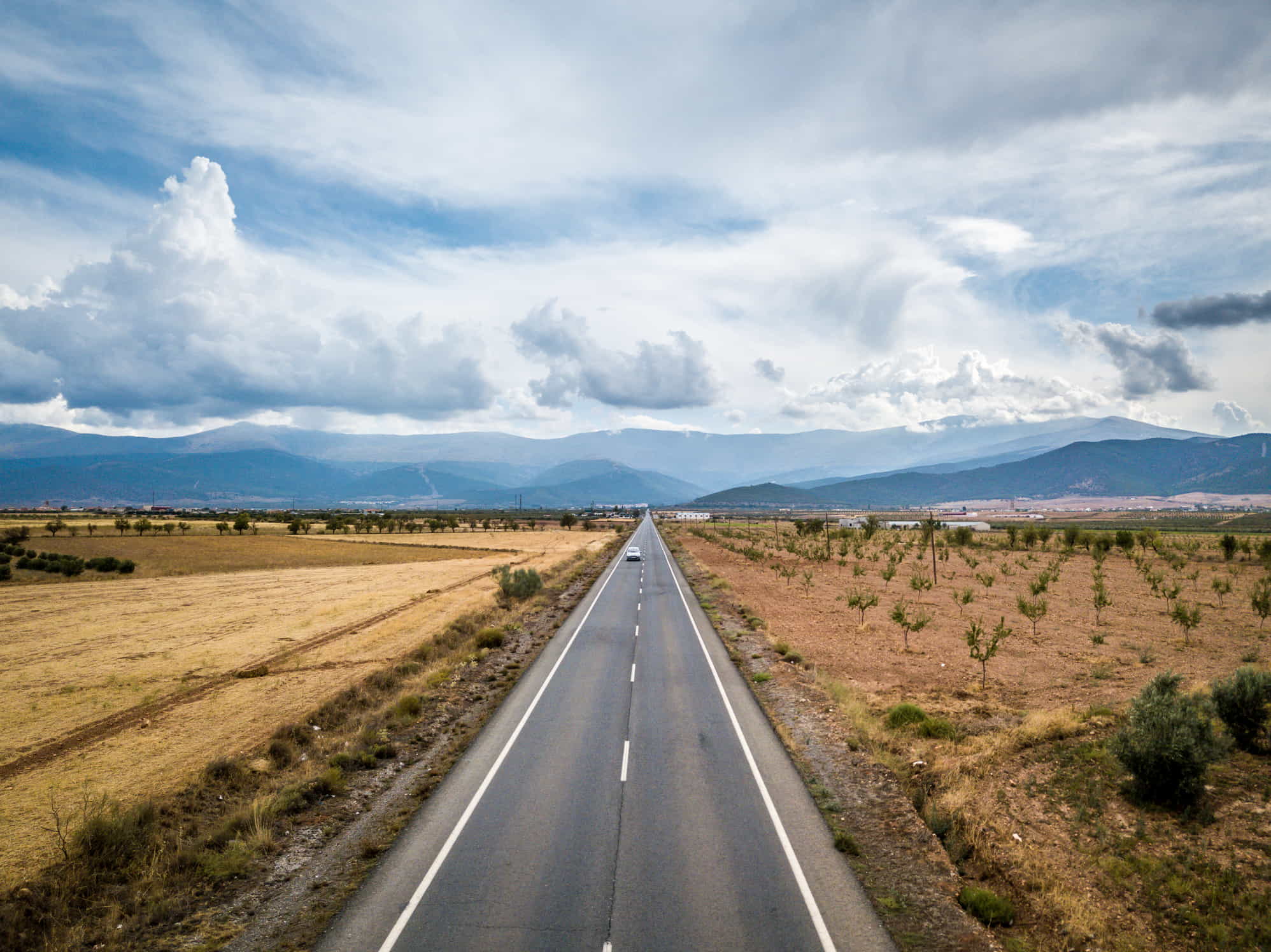 aerial view of straight tarred road for long distance moving